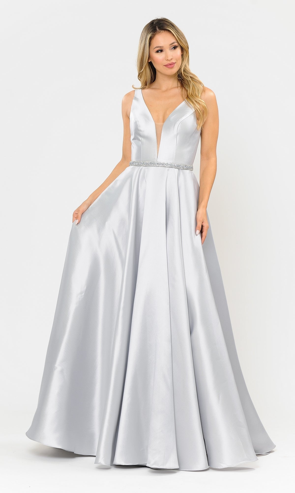 A woman models the Deep V-Neck Long Mikado A-Line Prom Dress 8682, a sleeveless silver floor-length gown, holding the skirt's sides while standing against a plain white background.